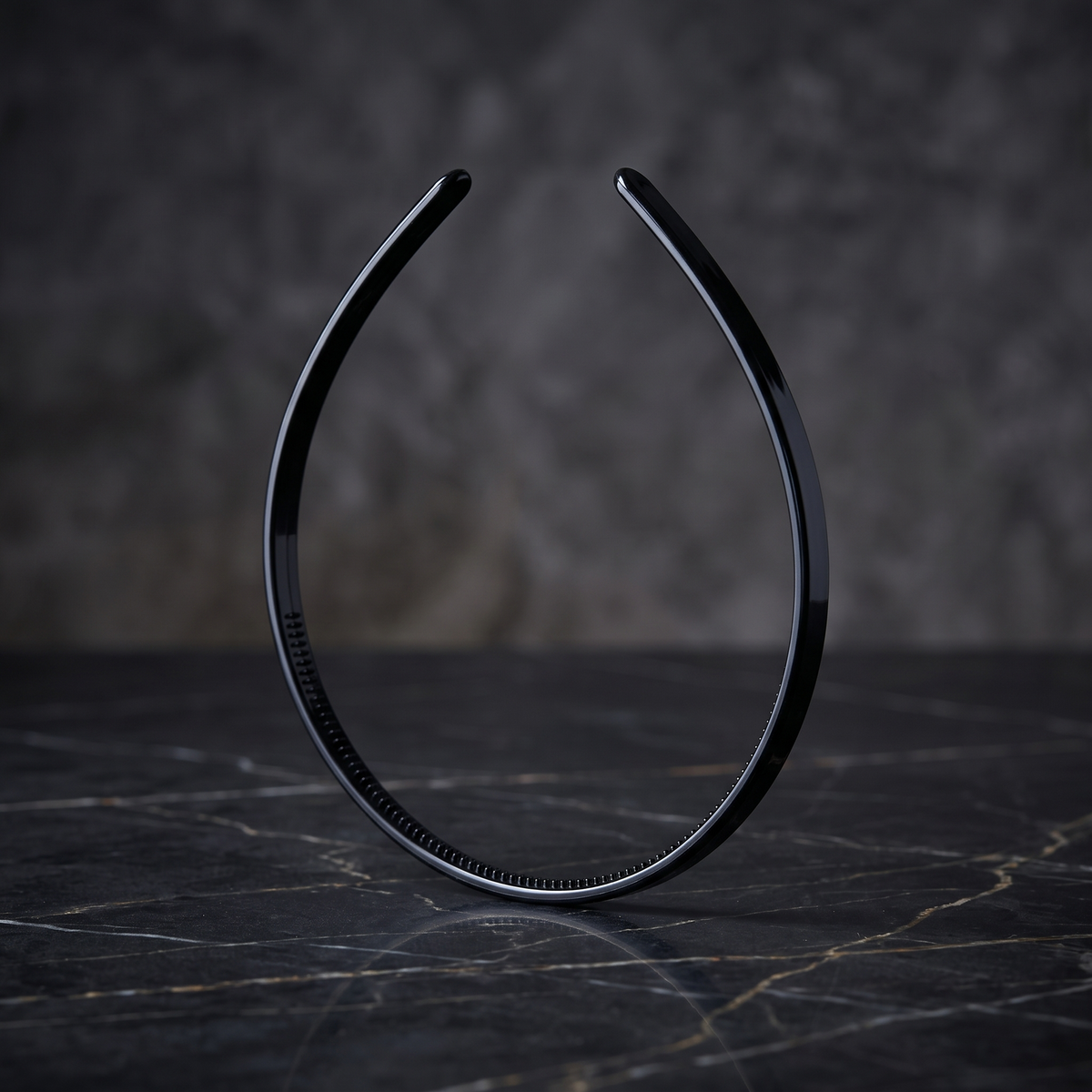 Thin black headband on dark marble