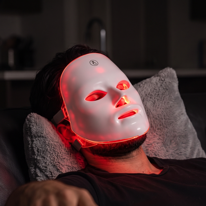 Man relaxing wearing the LED face mask glowing red