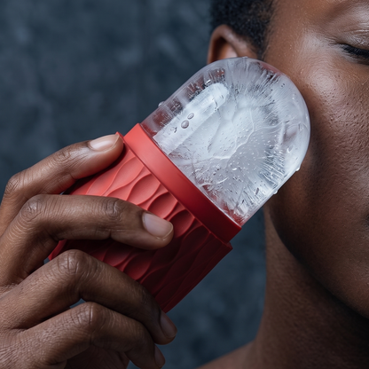 Close-up of the red silicone ice roller held against the cheek